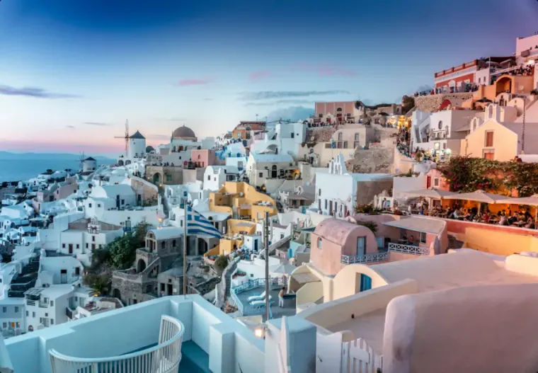 Casas brancas com vista para o mar em Santorini ao pôr do sol